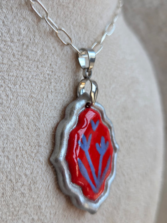Medalla rojo y azul marino con pátina plateada y cadena con baño de plata