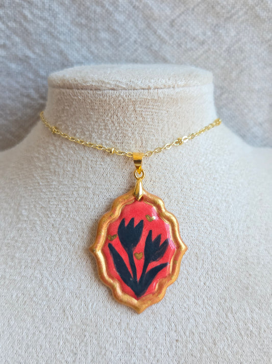 Medalla coral y azul marino con pátina dorada, detalles en oro y cadena con baño de oro