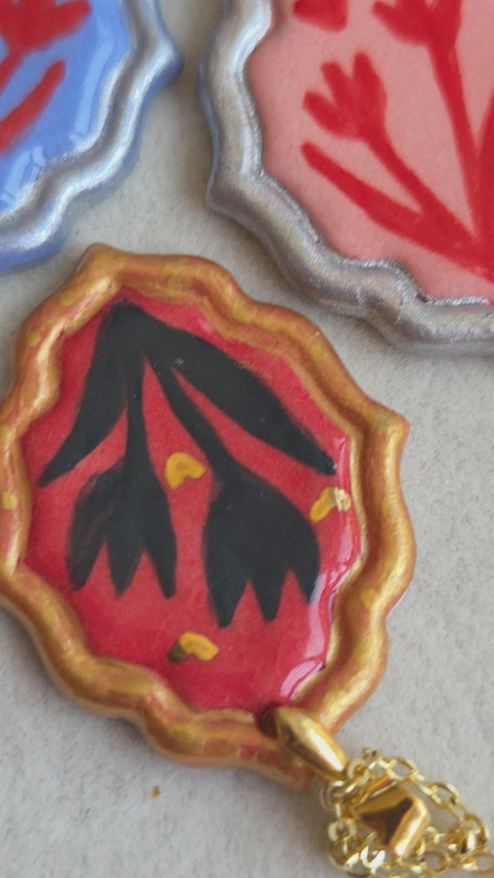 Medalla coral y verde con pátina plateada y cadena con baño de plata