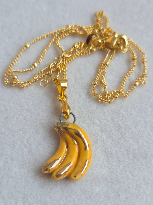 Dije de plátano en racimo con oro