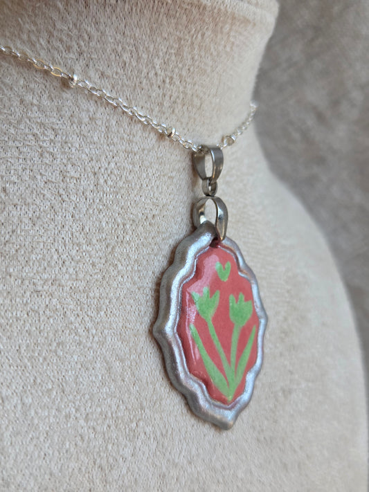 Medalla coral y verde con pátina plateada y cadena con baño de plata