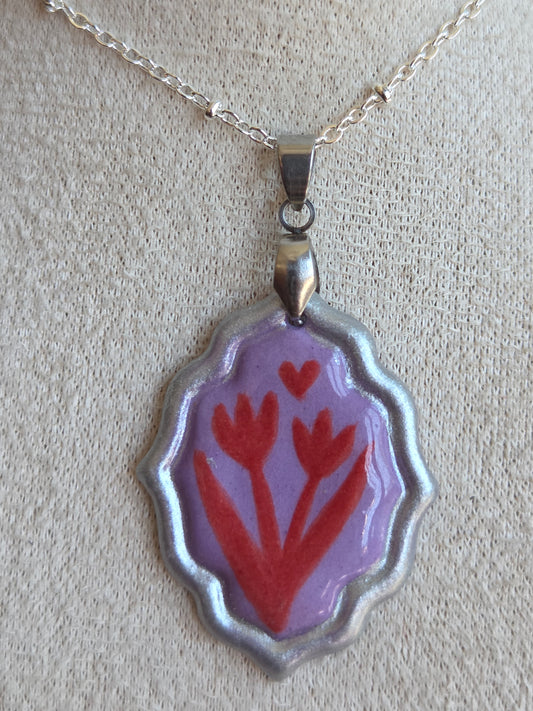 Medalla lila y rojo con pátina plateada y cadena con baño de plata