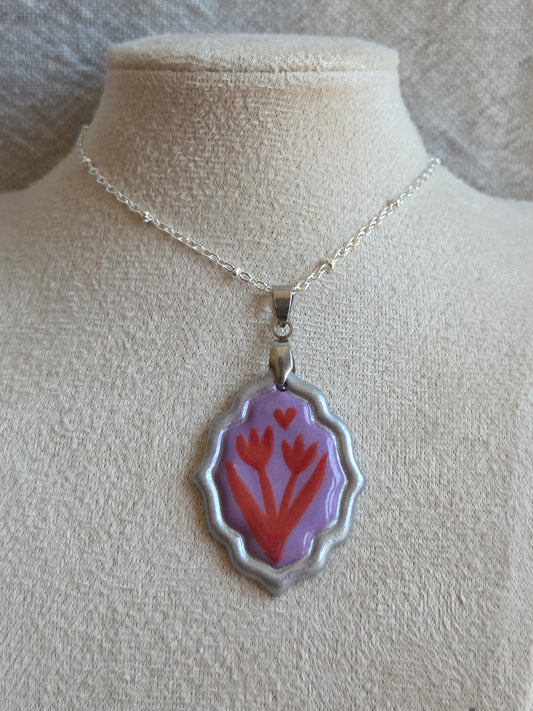 Medalla lila y rojo con pátina plateada y cadena con baño de plata